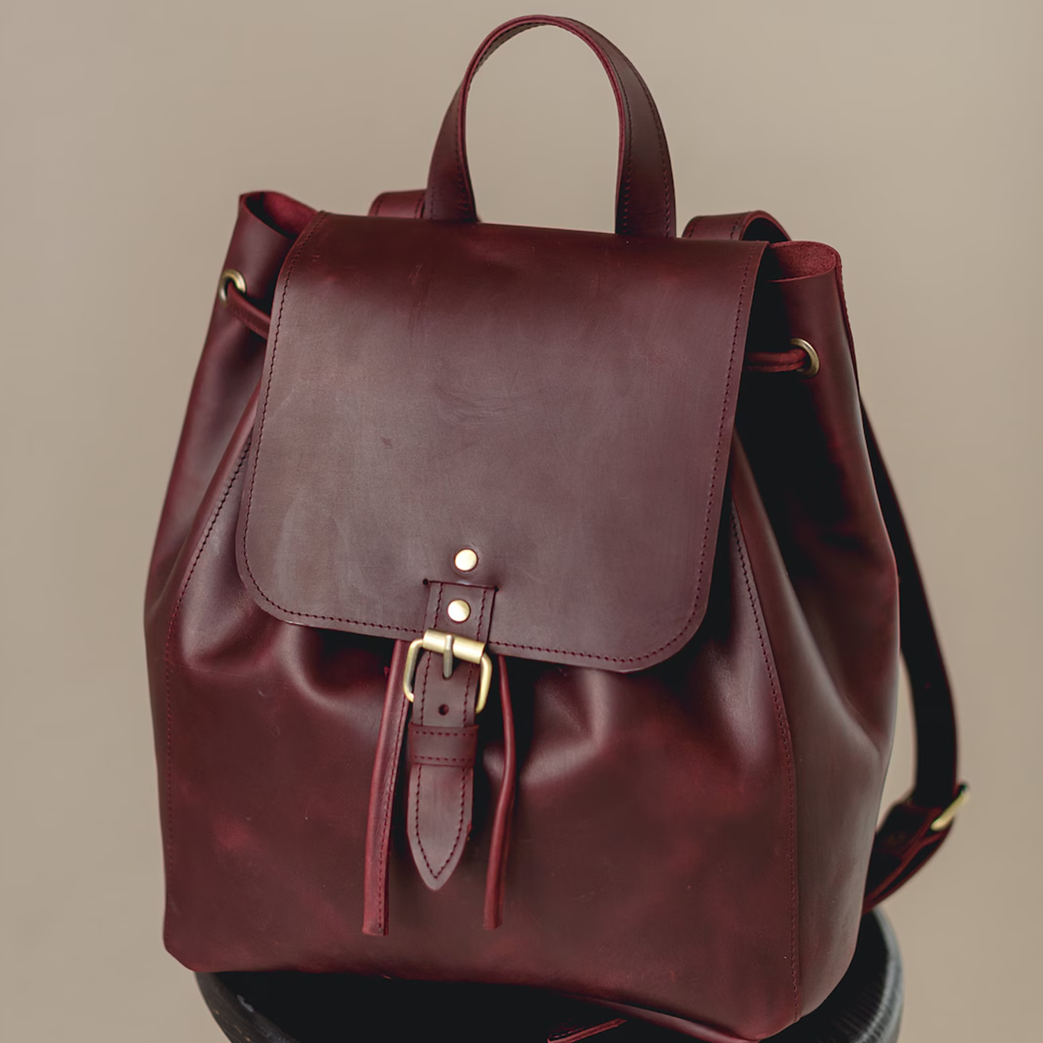 Deep Burgundy Smooth Grain Drawstring Bucket Haversack With Brass Buckle Flap Closure, Curved Top Handle And Adjustable Shoulder Straps